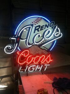 A neon sign for reno aces and coors light.