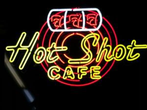 A neon sign that reads " hot shot cafe ".