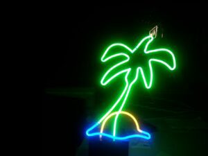 A neon palm tree is lit up in the dark.