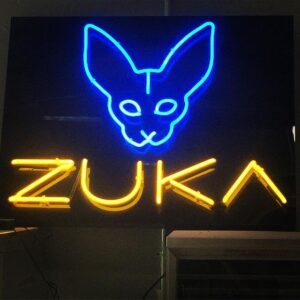 A neon sign that says zuka with an image of a cat.