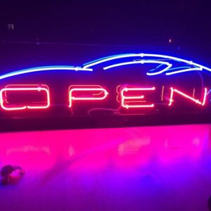 A neon sign that says open with a car on it.