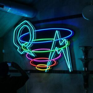 A neon sign that is hanging on the wall.